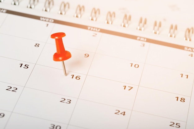 mark the event day with a pin Thumbtack in calendar concept for busy timeline organize scheduleappointment meeting reminder planning business meeting or travel holiday planning concept soft focus