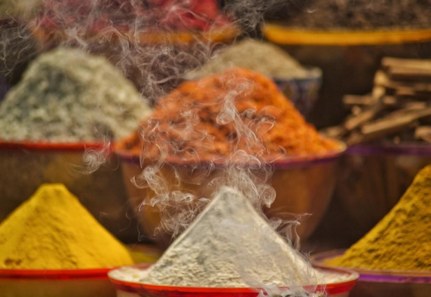 A market stall with spices and a smoke coming out of the top.