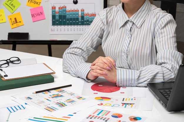 Marketing business lady in grey blazer in office with computer holding hands together close up