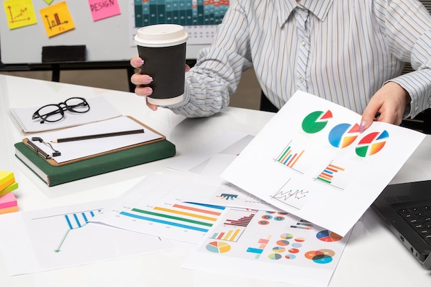 Photo marketing business lady in striped shirt in office with computer with glasses and coffee cup