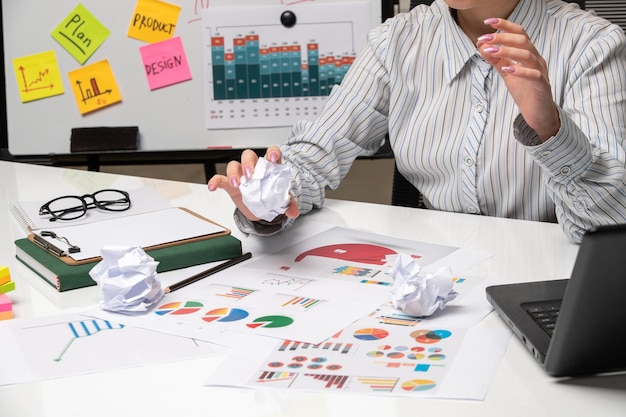 Marketing business lady in striped shirt in office with glasses on desk with crumpled paper