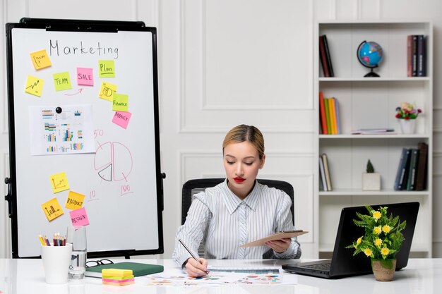 marketing smart cute business lady in striped shirt in office taking down notes of new project