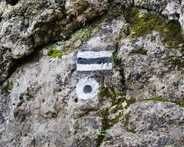 Marking the tourist route painted on the stone. Travel route sign.