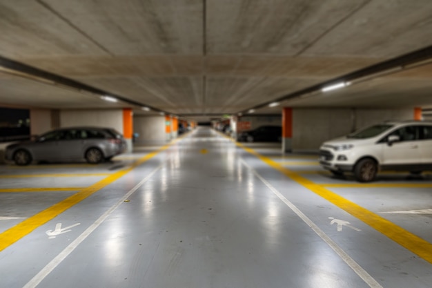 Photo markings with blurred modern cars parked inside an underground parking lot.