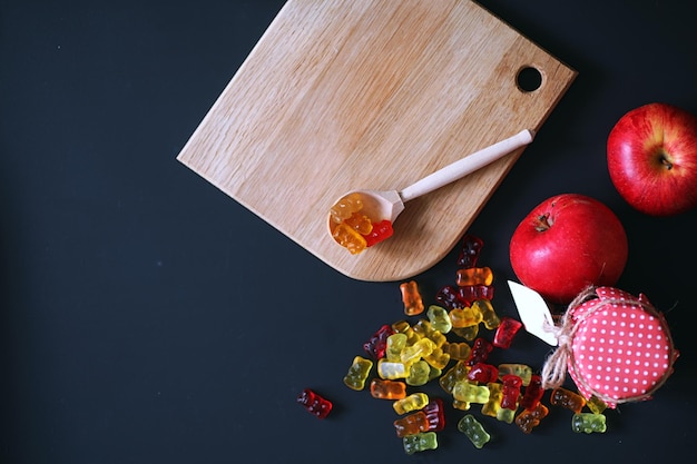 Marmelade in een vaas op tafel Snoepjes in een kom op een zwarte achtergrond Veelkleurige geleisnoepjes voor kinderen