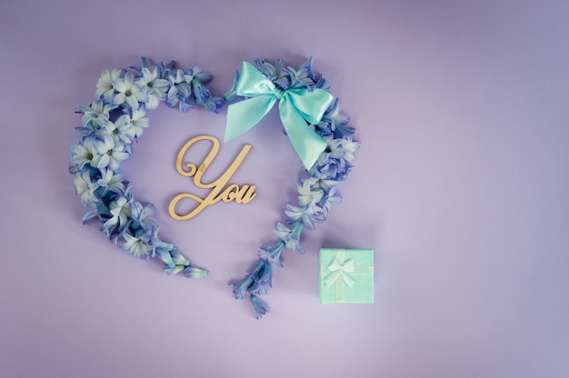 A marriage proposal. Will you marry me? Heart made from hyacinth flowers with mint bow 