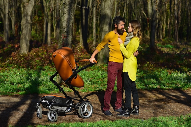 Married couple enjoy walking in spring park with baby pram Family enjoy sunny day outdoor Find what brings you joy and go there