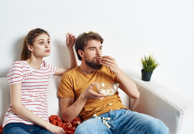 Premium Photo Married couple at home on the couch with popcorn emotions watching movies image