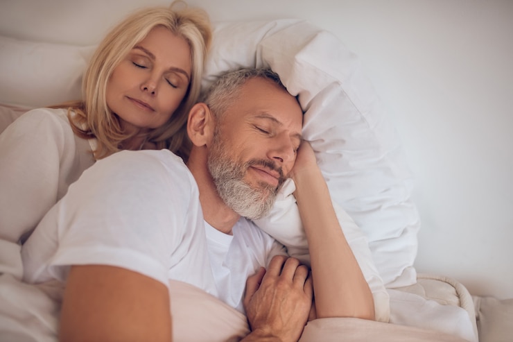 Photo married couple sleeping on a bed and looking peaceful