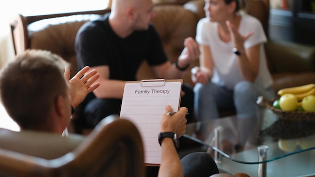 A married couple speaks with a psychologist a closeup family therapy consultation