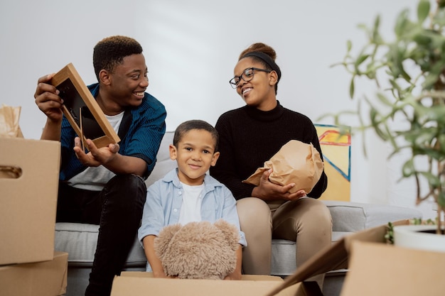 Married couple and their son unpack boxes after moving find mementos reminisce about old times