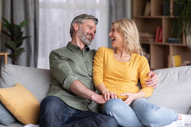 Married Middle Aged Couple Having Fun While Relaxing On Couch At Home