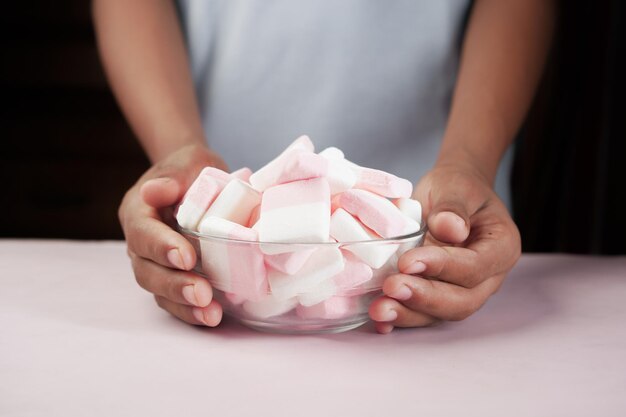 Marshmallow candy in a bowl on blue