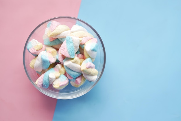 Marshmallow candy in a bowl on blue