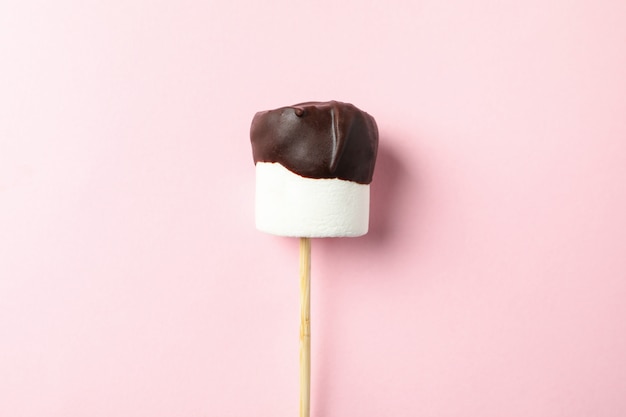 Marshmallow in chocolate on pink background. Sweet food