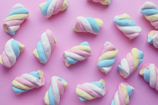 Photo marshmallow closeup of colorful gummies on a pink background candies