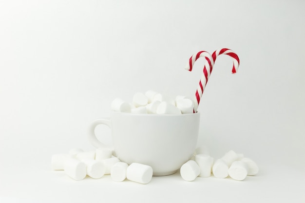 Photo marshmallow in the cup on the white surface.