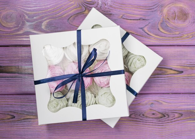 Marshmallow in a gift box on a wooden background Sweet gift