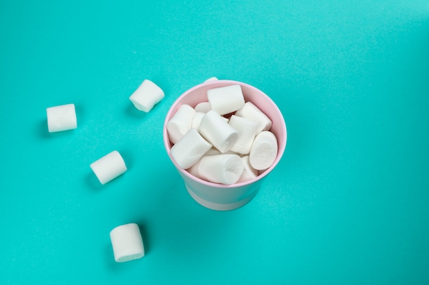 Marshmallow laid out on blue paper. pastel creative textured pattern.