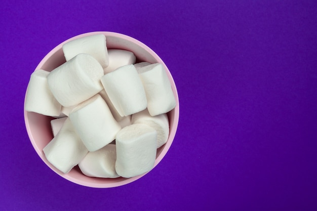 Marshmallow laid out on violet paper.