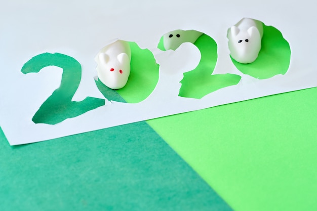 Foto marshmallow-muizen kijken door uitgesneden papier nummer 2020, gelukkig nieuwjaar van de muis!