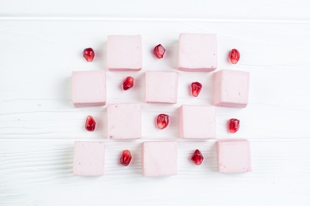 Marshmallow and pomegranate on a wooden table