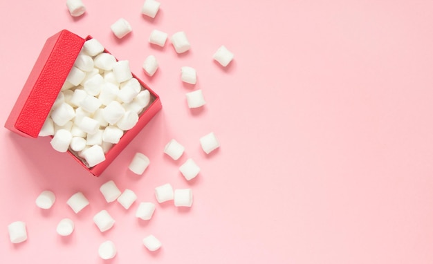 Marshmallow in red present gift box on a pink background Concept of love