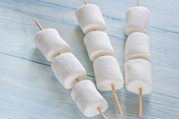 Marshmallow skewers on the wooden table