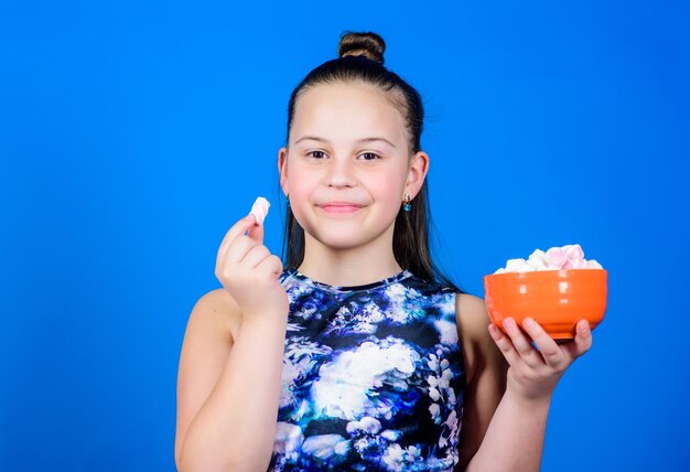 Marshmallow Snoepwinkel gelukkig klein kind liefde snoep en lekkernijen Gezond eten en tandheelkundige kinderopvang Diëten en calorieën Zoetekauw concept Klein meisje eet marshmallow gelukkig klein kind