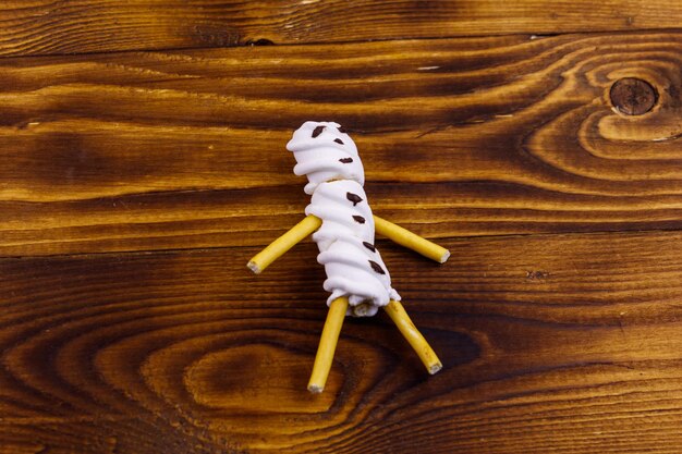 Foto un pupazzo di neve di marshmallow su sfondo di legno