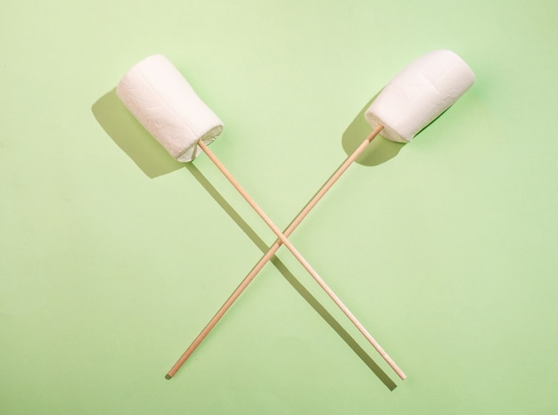 Photo marshmallow on a stick with a cross on a bright golden background