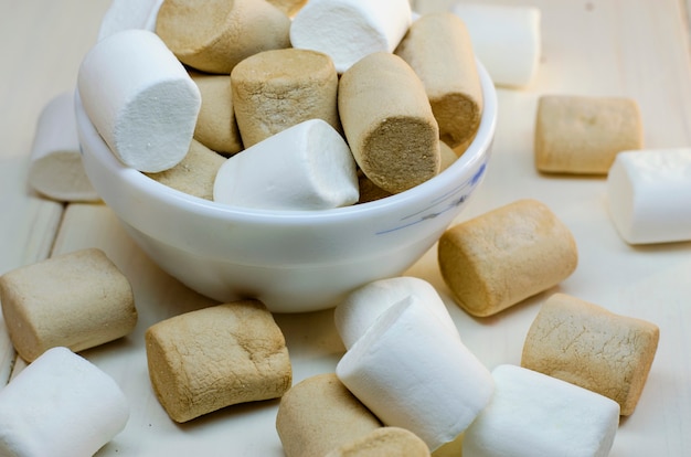 Marshmallow bianco e colori caffè su una superficie bianca