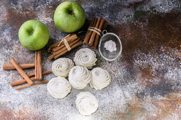 Marshmallow with cinnamon and apple on concrete 