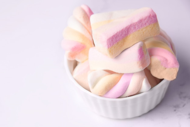 Marshmallows in a bowl on a white background close-up copy space