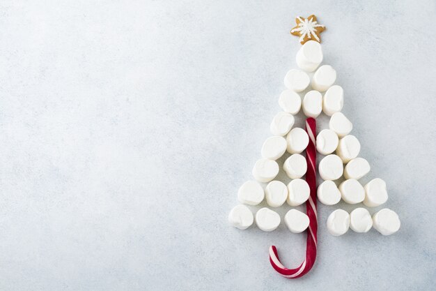 Marshmallows and Christmas lollipop on gray background