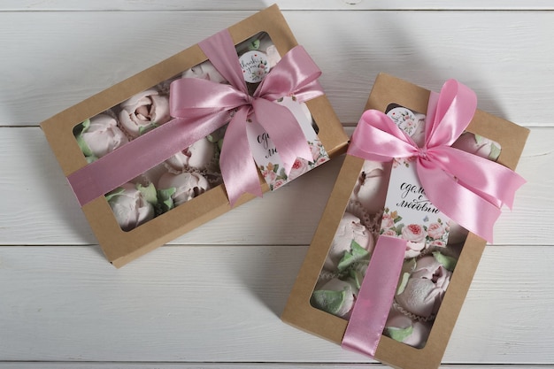 Foto marshmallows in scatole regalo con un coperchio trasparente le scatole sono legate con il nastro adesivo