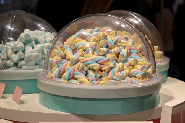 Marshmallow sotto una fiaschetta di vetro in un negozio di diverse forme e colori