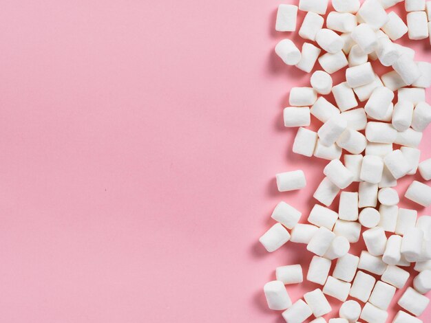 Photo marshmallows on pink background with copyspace