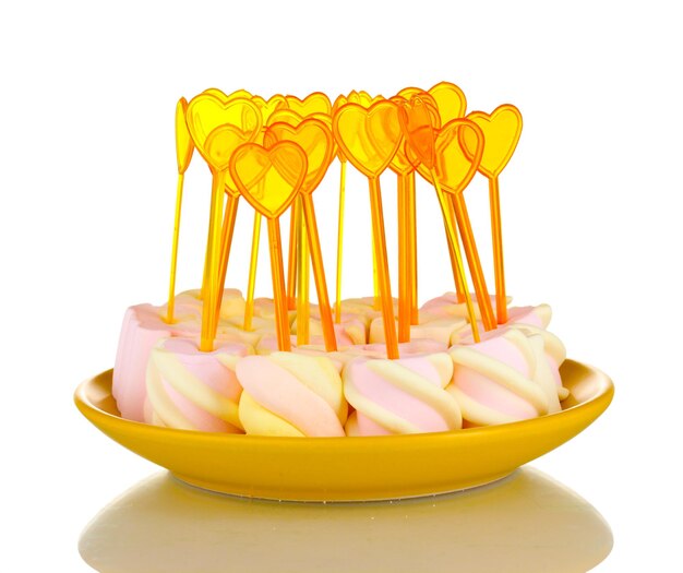 Marshmallows with skewers on plate isolated on white