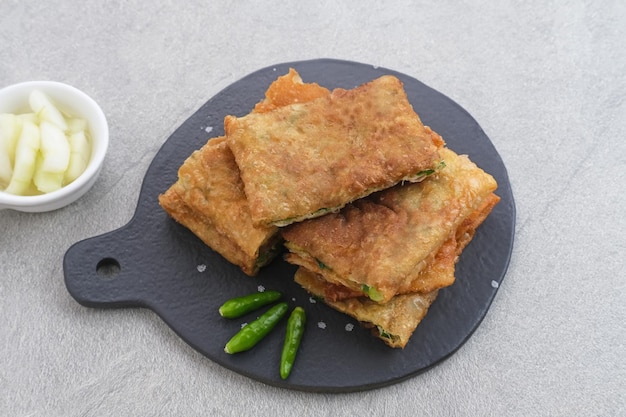 Photo martabak or mutabbaq, savory pan-fried pastry stuffed with egg, meat and spices