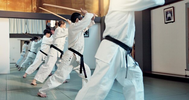 Foto martial arts aikido klas en mensen met training discipline zelfverdediging en oefenen zwaardtechniek zwarte gordel studenten japanse groep en leren vaardigheden ontwikkeling voor bescherming in dojo