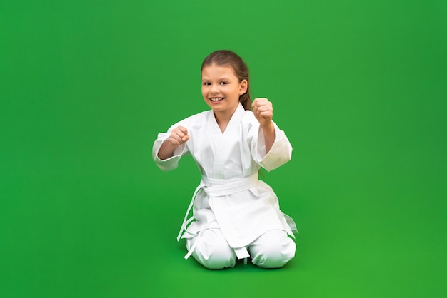 Corsi di arti marziali karate scuola per bambini preparazione per l'allenamento di wrestling sviluppo di un bambino nelle arti marziali una ragazza con un kimono bianco