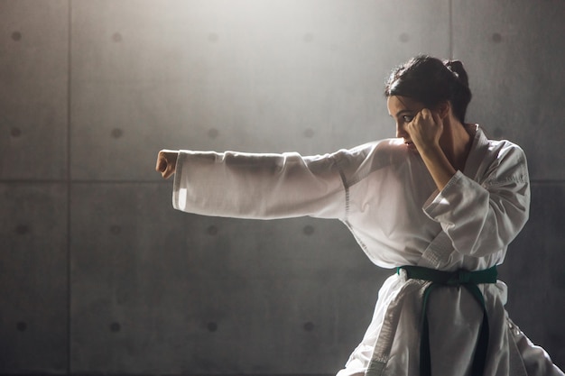 写真 武道の概念。空手を練習する着物の若い女性