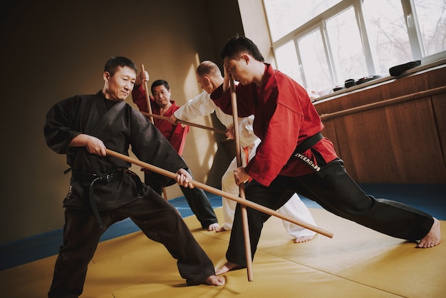 Martial arts fighters fighting with sticks.