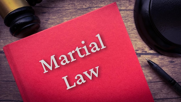 Martial law book and gavel on wooden table