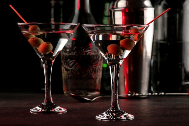Martini bevanda alcolica martini con olive in un bicchiere su uno sfondo scuro nel bar sul bancone del bar cocktail di inventario del bar