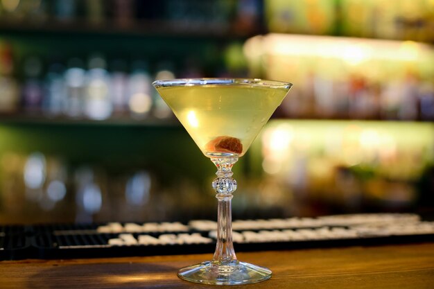 Martini glass on the bar counter in a nightclub with blurred background