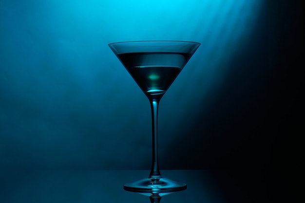 Bicchiere da martini con colore blu su fondo nero.