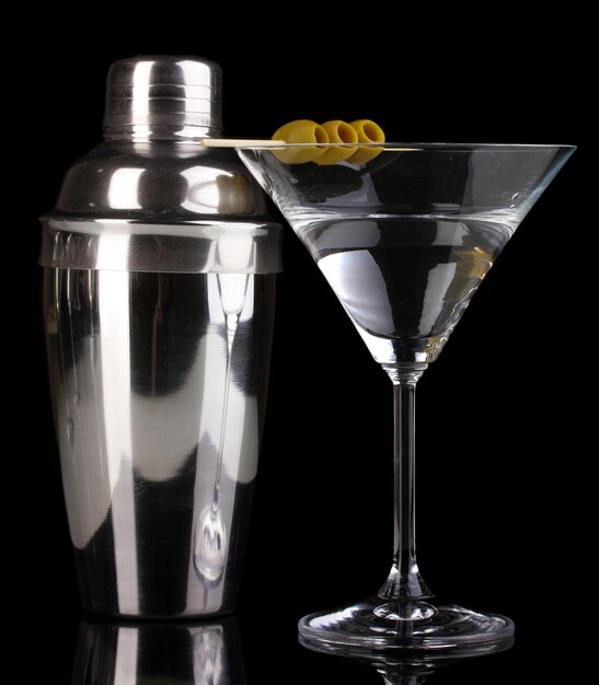 Bicchiere da martini con olive e shaker isolato su fondo nero
