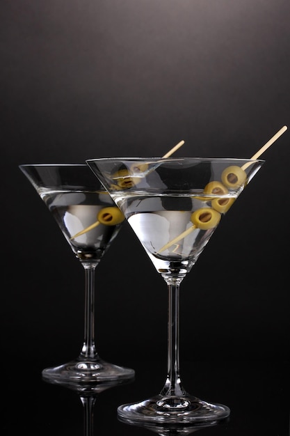 Martini glasses and olives on grey background